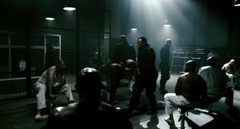 Movie still from “Gamer” (2009), directed by Mark Neveldine – A group of men sitting around in a room; Wide shot, High angle