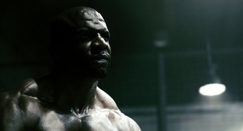 Movie still from “Gamer” (2009), directed by Mark Neveldine – A man's face in a dark room; Close Up shot, Low angle