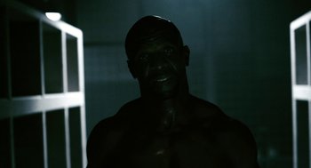 Movie still from “Gamer” (2009), directed by Mark Neveldine – A man with no shirt in a dark room; Close Up shot, Low angle
