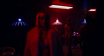 Movie still from “Gamer” (2009), directed by Mark Neveldine – A woman in a fur coat standing in a room; Wide shot, Over the shoulder angle