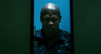 Movie still from “Gamer” (2009), directed by Mark Neveldine – A man with a gun in his hand is reflected in a mirror; Close Up shot, Low angle