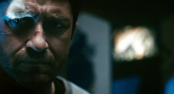 Movie still from “Gamer” (2009), directed by Mark Neveldine – A man's face in a dark room; Close Up shot, Low angle