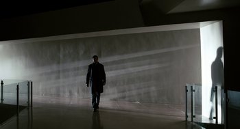 Movie still from “Gamer” (2009), directed by Mark Neveldine – A man is walking in the dark in front of a wall; Wide shot, Low angle