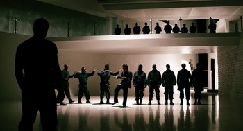 Movie still from “Gamer” (2009), directed by Mark Neveldine – A group of men standing in a room; Wide shot, Low angle