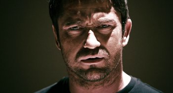 Movie still from “Gamer” (2009), directed by Mark Neveldine – A person with a frowning face; Close Up shot, Low angle