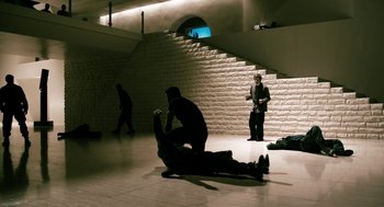 Movie still from “Gamer” (2009), directed by Mark Neveldine – A group of people sitting on the ground in a room; Wide shot, High angle