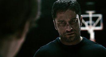 Movie still from “Gamer” (2009), directed by Mark Neveldine – A person wearing a black t - shirt; Close Up shot, Over the shoulder angle