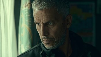 Movie still from “Ganglands” (2021), created by Julien Leclercq – A person wearing a shirt and a tie; Close Up shot, Low angle