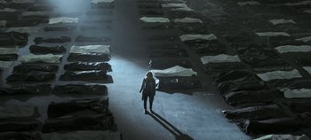 Movie still from “Black Mirror” (2011), created by Charlie Brooker – A woman walking in a room with many beds in it; Extreme Wide shot, High angle