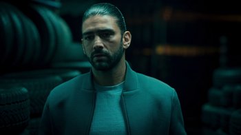 Movie still from “Ganglands” (2021), created by Julien Leclercq – A person wearing a jacket; Close Up shot, Over the shoulder angle