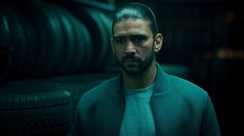 Movie still from “Ganglands” (2021), created by Julien Leclercq – A person wearing a jacket; Close Up shot, Low angle