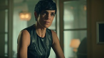 Movie still from “Ganglands” (2021), created by Julien Leclercq – A woman with short black hair wearing a leather top; Close Up shot, Low angle