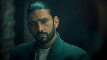 Movie still from “Ganglands” (2021), created by Julien Leclercq – A person wearing a jacket; Close Up shot, Over the shoulder angle