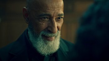 Movie still from “Ganglands” (2021), created by Julien Leclercq – An old man with a beard and a goatee; Close Up shot, Over the shoulder angle