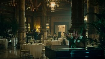 Movie still from “Ganglands” (2021), created by Julien Leclercq – A room filled with lots of tables and chairs; Extreme Wide shot, High angle