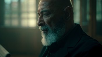 Movie still from “Ganglands” (2021), created by Julien Leclercq – An older man with a beard is looking into the distance; Close Up shot, Low angle