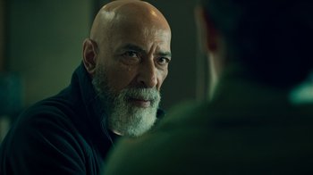 Movie still from “Ganglands” (2021), created by Julien Leclercq – An older man with a beard is talking to a younger man; Close Up shot, Over the shoulder angle