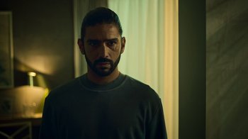 Movie still from “Ganglands” (2021), created by Julien Leclercq – A person wearing a shirt; Close Up shot, Over the shoulder angle