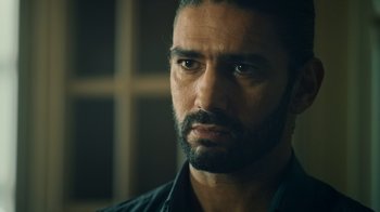 Movie still from “Ganglands” (2021), created by Julien Leclercq – A person with a beard looking at the camera; Close Up shot, Over the shoulder angle