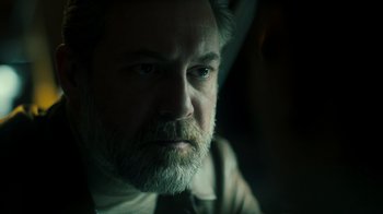 Movie still from “Ganglands” (2021), created by Julien Leclercq – A person with a beard looking at the camera; Close Up shot, Low angle