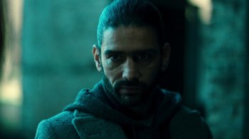 Movie still from “Ganglands” (2021), created by Julien Leclercq – A person wearing a jacket; Close Up shot, Over the shoulder angle