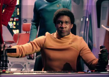 Movie still from “Black Mirror” (2011), created by Charlie Brooker – A man sitting at a desk in front of a computer screen; Medium shot, Over the shoulder angle