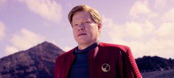 Movie still from “Black Mirror” (2011), created by Charlie Brooker – A man wearing a red jacket and a star trek badge; Close Up shot, Over the shoulder angle