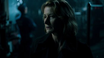 Movie still from “Ganglands” (2021), created by Julien Leclercq – A woman with long hair is looking into the distance; Close Up shot, Over the shoulder angle