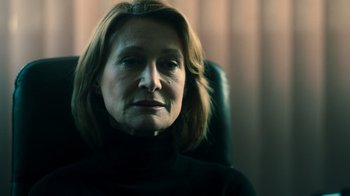 Movie still from “Ganglands” (2021), created by Julien Leclercq – A person sitting in a chair looking at the camera; Close Up shot, Over the shoulder angle