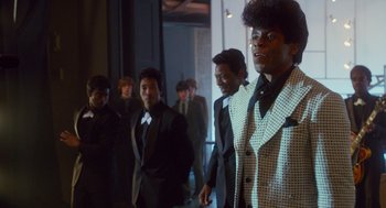Movie still from “Get on Up” (2014), directed by Tate Taylor – A group of men in suits and ties standing in front of a building; Medium shot, Low angle