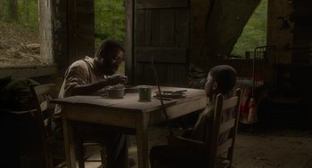 Movie still from “Get on Up” (2014), directed by Tate Taylor – Two men sitting at a table in front of each other; Medium shot, High angle