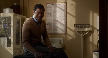 Movie still from “Get on Up” (2014), directed by Tate Taylor – A man sitting in front of a bathroom sink; Medium shot, Over the shoulder angle