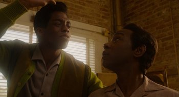Movie still from “Get on Up” (2014), directed by Tate Taylor – Two men looking up at each other in a dimly - lit room; Close Up shot, Over the shoulder angle
