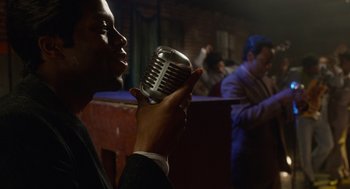 Movie still from “Get on Up” (2014), directed by Tate Taylor – A man holding a microphone up to his mouth; Close Up shot, Low angle