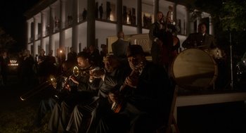 Movie still from “Get on Up” (2014), directed by Tate Taylor – A group of men sitting next to each other on a stage; Extreme Wide shot, High angle