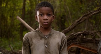 Movie still from “Get on Up” (2014), directed by Tate Taylor – A young boy is standing in front of a tree; Close Up shot, High angle