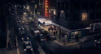 Movie still from “Get on Up” (2014), directed by Tate Taylor – People are walking down the street at night in the dark; Extreme Wide shot, High angle