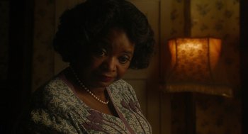 Movie still from “Get on Up” (2014), directed by Tate Taylor – An older black woman wearing a dress and a pearl necklace; Close Up shot, Over the shoulder angle
