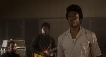 Movie still from “Get on Up” (2014), directed by Tate Taylor – Two men are playing guitar in a dark room; Medium shot, Over the shoulder angle