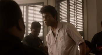 Movie still from “Get on Up” (2014), directed by Tate Taylor – A man standing next to another man in front of a window; Medium shot, Over the shoulder angle