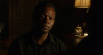 Movie still from “Get on Up” (2014), directed by Tate Taylor – A man in a black shirt is in a dark room; Close Up shot, Over the shoulder angle