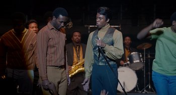 Movie still from “Get on Up” (2014), directed by Tate Taylor – Two men are singing in front of a band; Medium shot, Over the shoulder angle