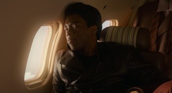 Movie still from “Get on Up” (2014), directed by Tate Taylor – A man sitting on a plane looking out the window; Close Up shot, Over the shoulder angle