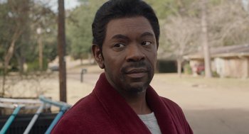 Movie still from “Get on Up” (2014), directed by Tate Taylor – A person wearing a red robe; Close Up shot, Over the shoulder angle