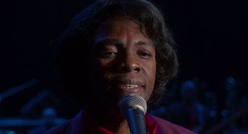 Movie still from “Get on Up” (2014), directed by Tate Taylor – A person with a microphone in front of a crowd; Extreme Close Up shot, High angle