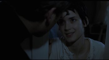 Movie still from “Girl, Interrupted” (1999), directed by James Mangold – A young woman smiles at the camera in a dark room; Close Up shot, Over the shoulder angle