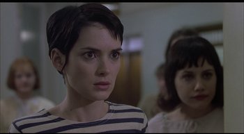Movie still from “Girl, Interrupted” (1999), directed by James Mangold – A woman with short black hair wearing a striped shirt; Close Up shot, Over the shoulder angle