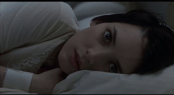 Movie still from “Girl, Interrupted” (1999), directed by James Mangold – A woman laying in a bed with her head on a pillow; Close Up shot, High angle