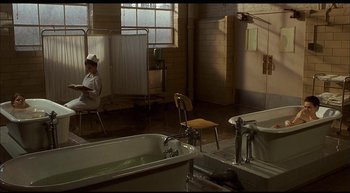 Movie still from “Girl, Interrupted” (1999), directed by James Mangold – A man sitting in a room next to a bath tub; Wide shot, High angle