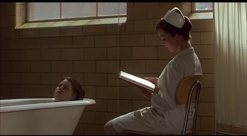 Movie still from “Girl, Interrupted” (1999), directed by James Mangold – A nurse reading a book to a patient in a bath tub; Medium shot, High angle